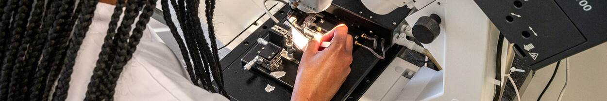 woman performs research with microscope