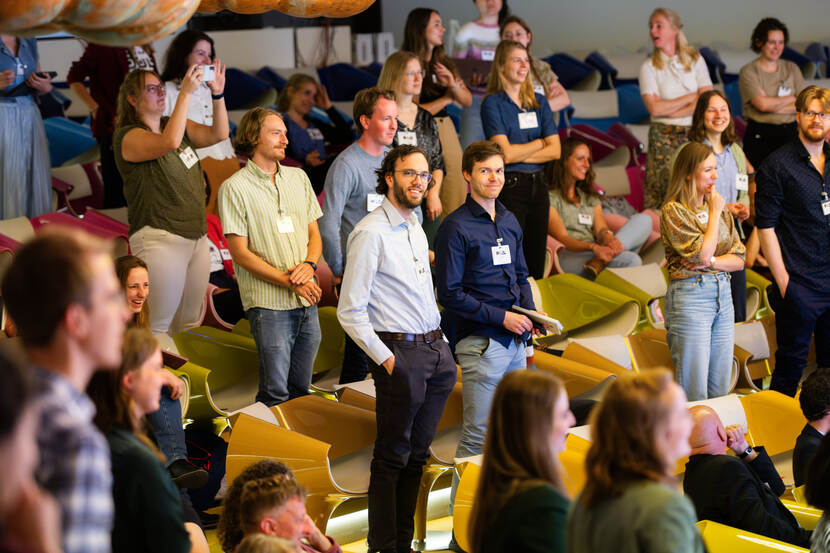 zaal met zittende en staande mensen